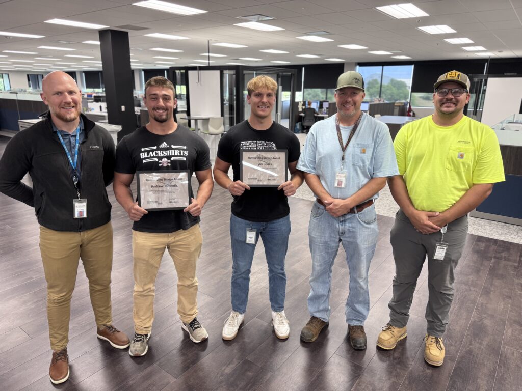 5 M.U.D. employees stand next to each other smiling, including two summer hires who helped driver